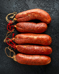 traditional Balearic raw cured meat sobrassada sausage made from ground pork, paprika and spices on rustic black background