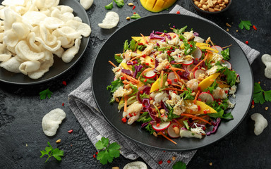 Crab salad with vegetables, radish, carrots, mango, pine nuts and prawn crackers