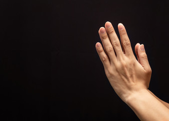 Praying hands in the dark background with faith in religion and belief in God.