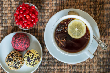 Spice tea, consisting of cinnamon, black pepper, cardamom, star anise, lemon, cloves and hot apple juice. Close up, top view