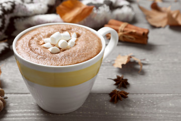 Cup of hot drink on grey wooden table, closeup. Cozy autumn atmosphere