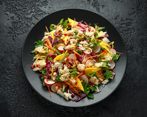 Crab salad with vegetables, radish, carrots, mango, pine nuts and prawn crackers