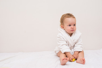 baby with a towel after the shower in bed at home