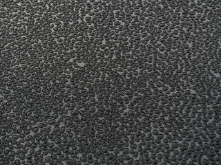 Rain drops against dark glass background, selective focus