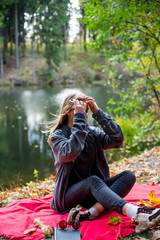 Vape teenager. Young beautiful white teenage girl in casual clothes vaping electronic cigarette near the river on the street in the park in the autumn evening. Bad habit. Vaping activity.