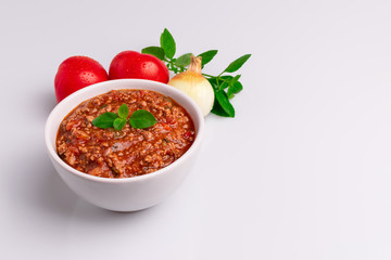 Bolognese (also know as Bolognesa or Bolonhesa) sauce in a white bowl isolated in white background, soft light, studio photo, copy space