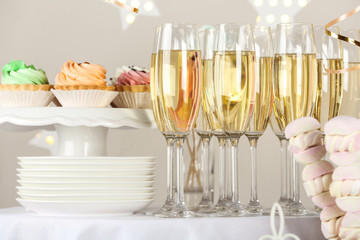 Candy bar with delicious treats and glasses of champagne for birthday party
