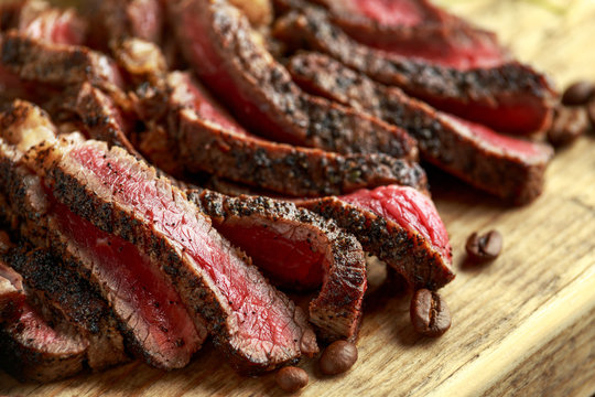 Freshly Cooked Seasoned With Home Made Coffee Rub Sliced Beef Steak Served On Wooden Board With Green Salad