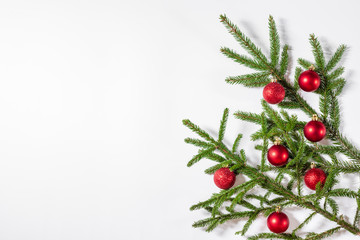 Christmas border of fir branches and red balls on a white background. Flat lay, top view, copy space. Christmas background