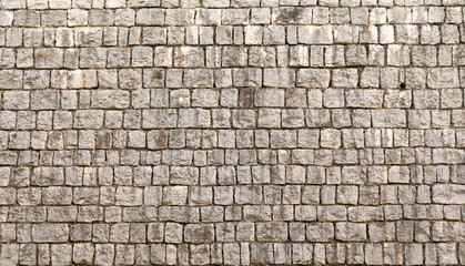 Texture of unshaped brown stone wall pattern, made of rocks