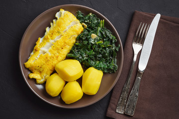 Pan-fried cod fillet, served with spinach and potatoes.          