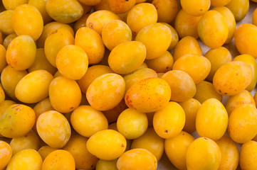 yellow fresh ripe plums placed on table in market. Vegetarian or healthy eating.