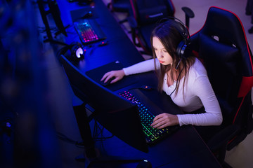 Obraz na płótnie Canvas Streamer beautiful girl professional gamer smile playing online games computer with headphones, neon color