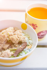 Homemade Rice, Chicken Soup in a Bowl with orange juice..Porridge with pork, breakfast of Asian people..Asian congee with minced pork in bowl.