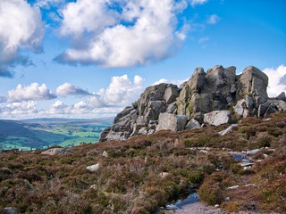A rocky, millstone outcrop near Simon's Seat on Barden Fell in the Yorkshire Dales, England, UK - taken on a sunny day in Autumn, with moorland heather in the foreground.