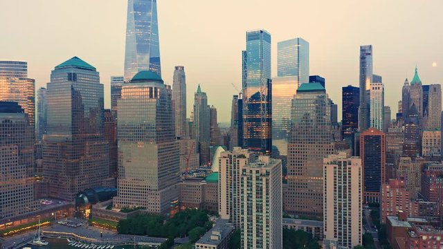 Drone footage with slow pull back away from New York City Lower Manhattan skyscrapers at dusk