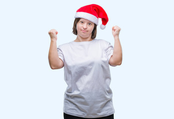 Fototapeta na wymiar Young adult woman with down syndrome wearing christmas hat over isolated background very happy and excited doing winner gesture with arms raised, smiling and screaming for success