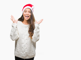 Obraz na płótnie Canvas Young arab woman wearing christmas hat over isolated background celebrating crazy and amazed for success with arms raised and open eyes screaming excited. Winner concept