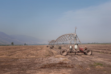watering machine on a field in the mountains