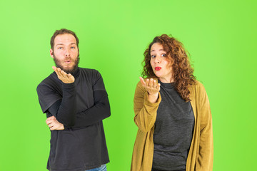 Beautiful young couple in love, kissing, throwing kisses with their hands. Romantic relationship.