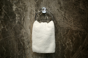 Face towel isolated hanging on the round circle metal hanger in the restroom.