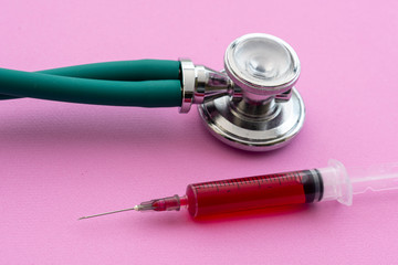 stethoscope with a vacuum tube full of blood on a lilac background © Celso Pupo