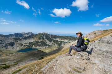 Young woman traveler in the bulgarian mountains , hiking in the sunny day