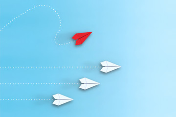 Leadership concept with red paper plane leading among white on blue background