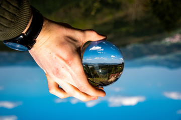 Glaskugel spiegelt die ganze Welt kleiner mit tollen wolken am Himmel