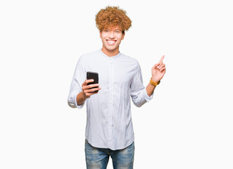 Young handsome man using smartphone very happy pointing with hand and finger to the side