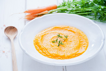 Creamy Carrot Soup on white wooden background