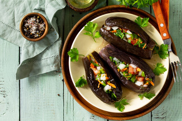 Healthy dinner. Snack. Stuffed with vegetables eggplant on wooden table. View from above. Free space for your text.