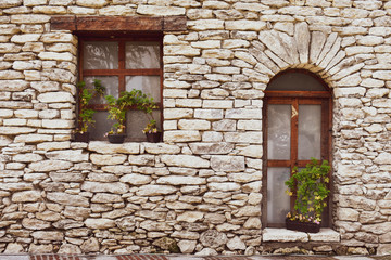 Fachada rústica de casa de ladrillos y piedra con puerta rústica de madera y vidrio - obrazy, fototapety, plakaty