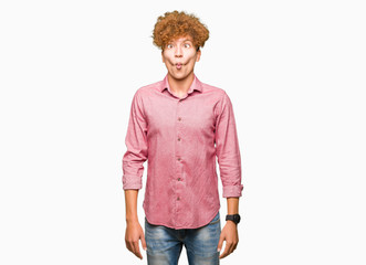 Young handsome business man with afro hair making fish face with lips, crazy and comical gesture. Funny expression.