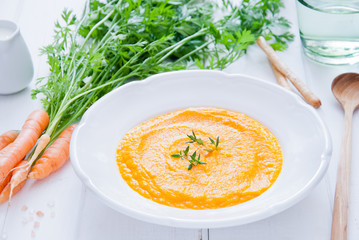 Creamy Carrot Soup on white wooden background