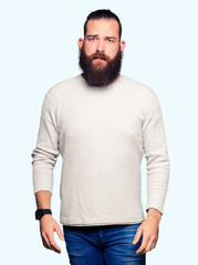 Fototapeta premium Young blond man wearing casual sweater depressed and worry for distress, crying angry and afraid. Sad expression.