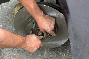 Replacement of worn disc brake system of the car. The mechanic carries out maintenance of brakes. Garage repair of the car.