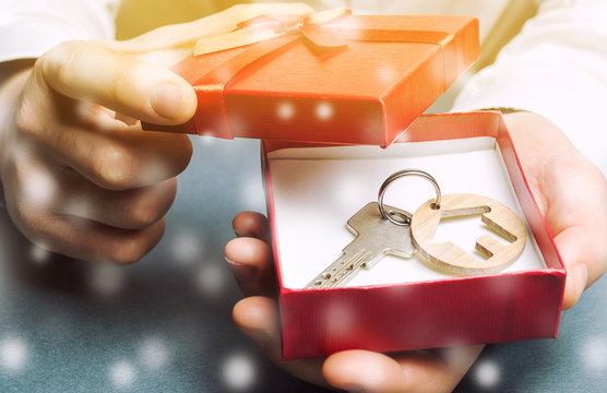 Keys With A House With A Gift Box And Snow. Great Offers For Real Estate In The Winter Season. Discounts And Sale Of Housing. New Year Promotions