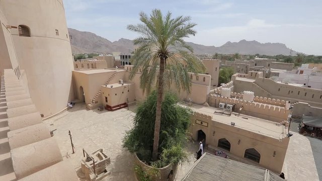 Nizwa Fort, Oman. Traditional Omani fortress, general plan and details. The territory of the fortress, palm trees, and traditional Japanese buildings