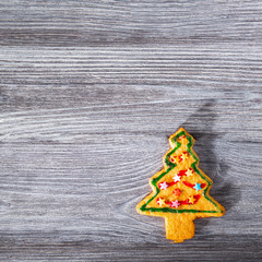 Traditional Christmas tree-shaped cookie on a gray wooden table.