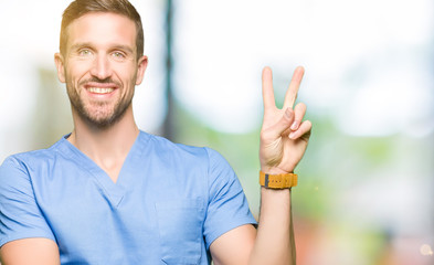 Handsome doctor man wearing medical uniform over isolated background smiling with happy face...