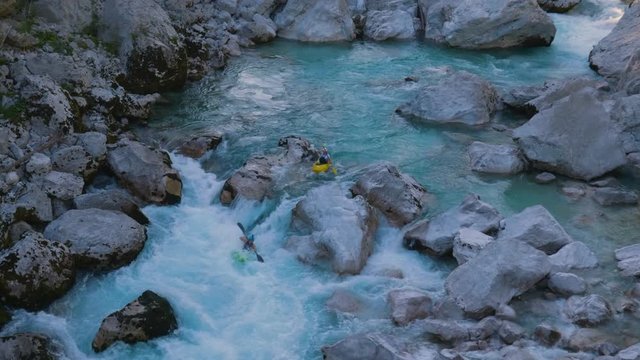 Two friends kayaking through rapids