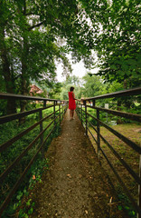 Woman in red dress on the forest walkway