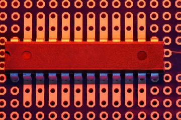 printed circuit board and microchip in red light closeup - electronic component for digital equipment, concept for development of electric computer circuits