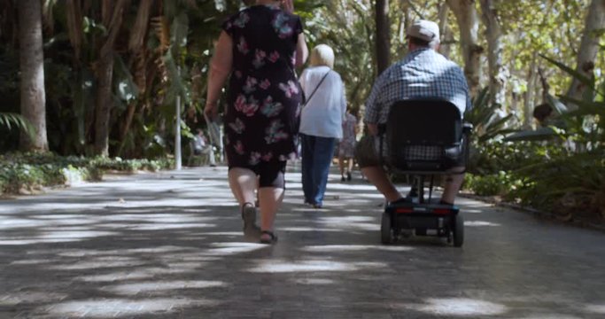 Barcelona, Spain - October 15, 2019: Motorized mobility scooter for elderly and or disabled.woman escorted a man on a mechanized wheelchair.
