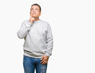 Fototapeta premium Middle age arab man wearing sport sweatshirt over isolated background with hand on chin thinking about question, pensive expression. Smiling with thoughtful face. Doubt concept.