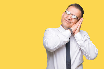 Middle age bussines arab man wearing glasses over isolated background sleeping tired dreaming and posing with hands together while smiling with closed eyes.