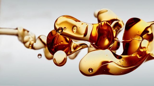 transparent orange gold oil bubbles and fluid shapes in purified water on a white gradient background. Side angle with crystal colored bubbles in purified cosmetic water backdrop with copy space for s