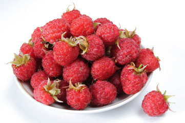 Ripe raspberry on a plate isolated on white