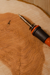 Close-up details of wood burning art and burning soldering iron